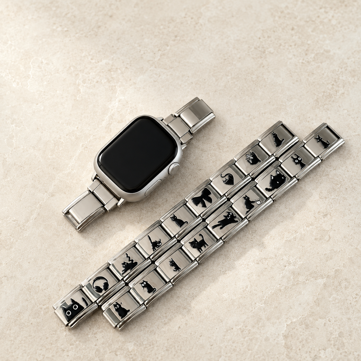 Silver cat Apple Watch band styled with jewelry in a light luxury flat lay