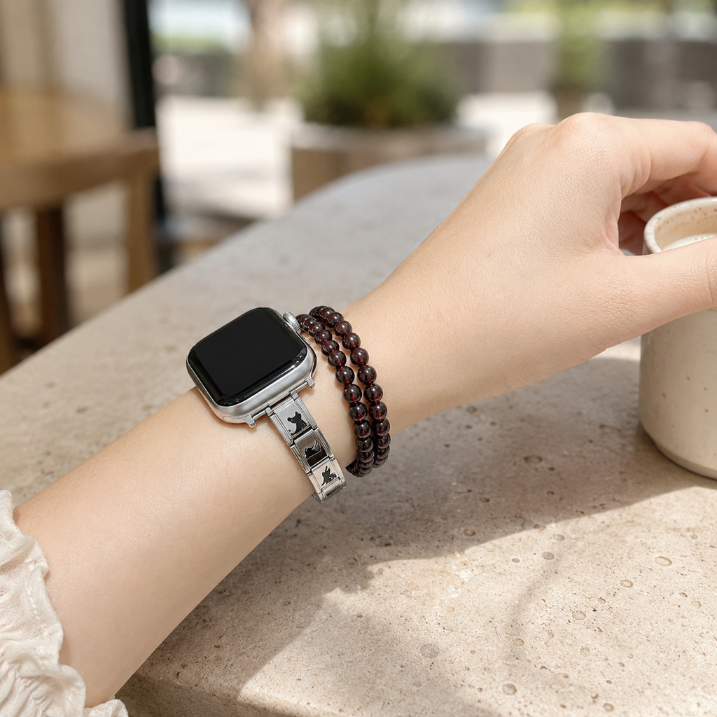 Woman wearing a silver cat Apple Watch band with minimalist stacked bracelets